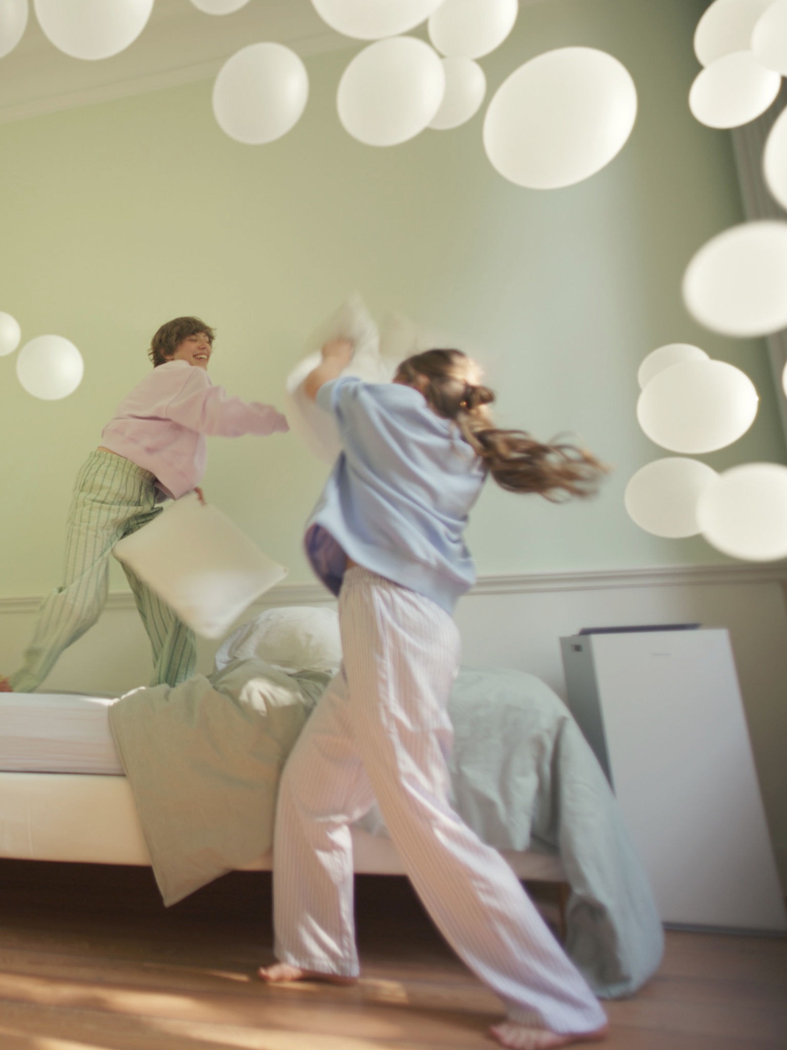 To piger leger i et soveværelse med afbalanceret luftfugtighed takket være Daikins luftrenser