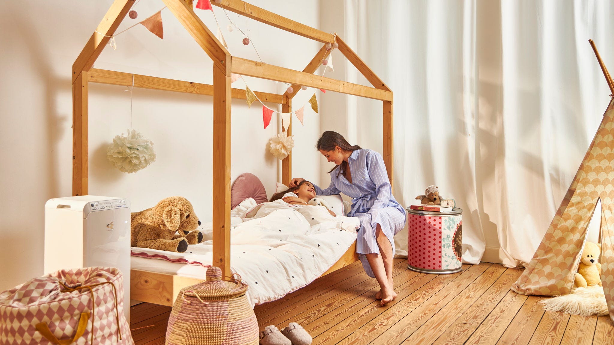 Mor, der putter sit barn på børneværelset, der har ren luft, takket være luftrenseren fra Daikin.