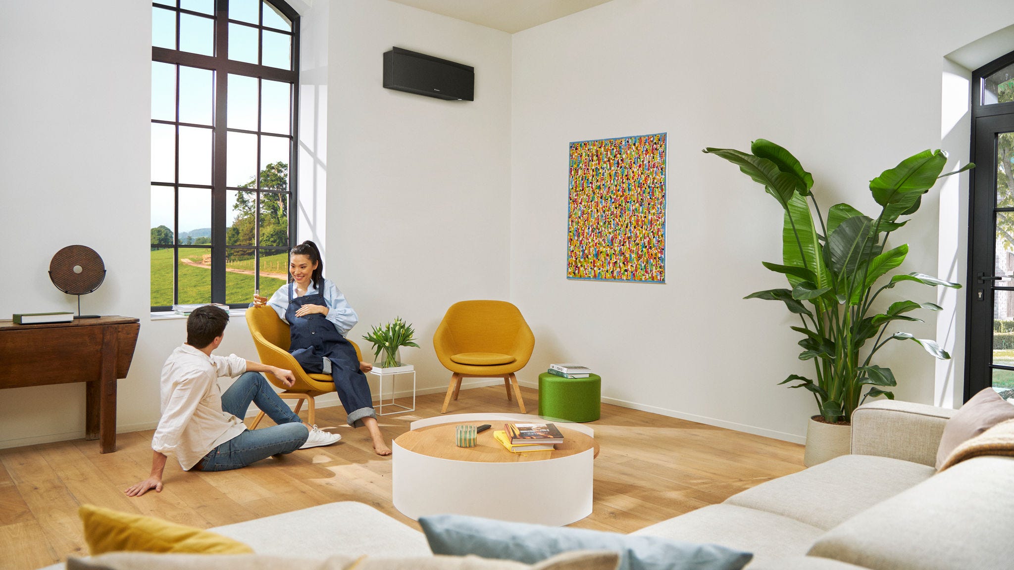 Vordende forældre taler afslappet med en kvinde, som sidder på en stol.