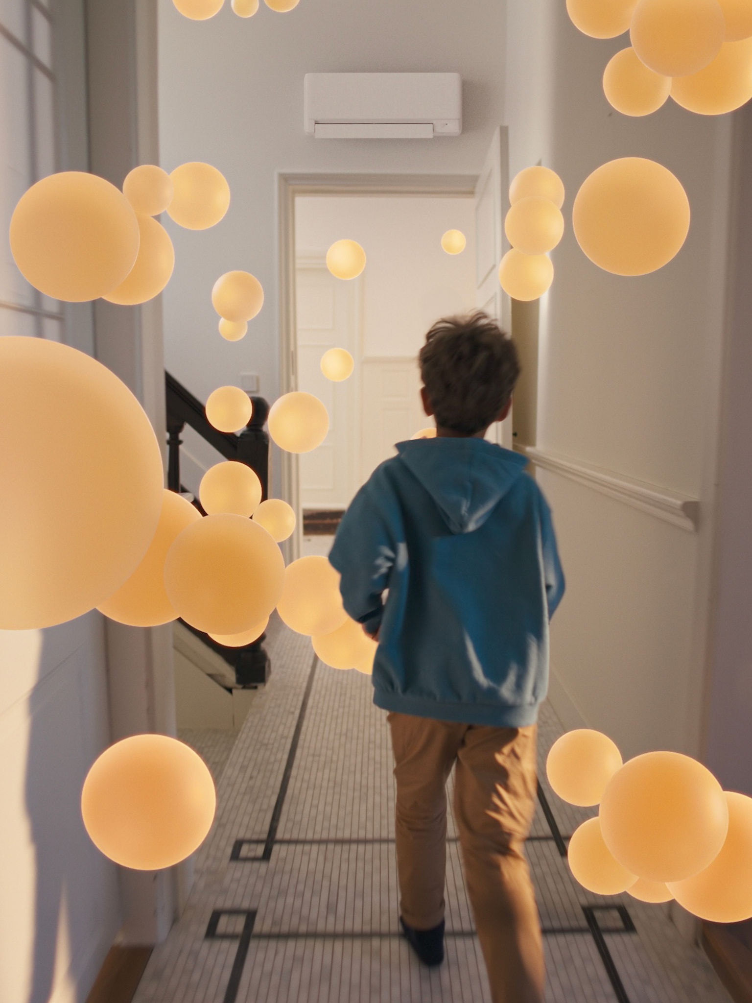 En dreng går gennem en gang med en ensartet, afbalanceret luftstrøm, som sikres ved hjælp af et veldesignet luft-til-luft-varmepumpesystem