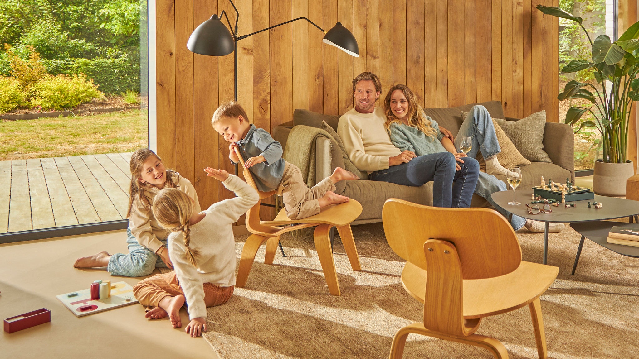 En familie på fire griner, mens de spiller et brætspil i deres ventilerede køkken.