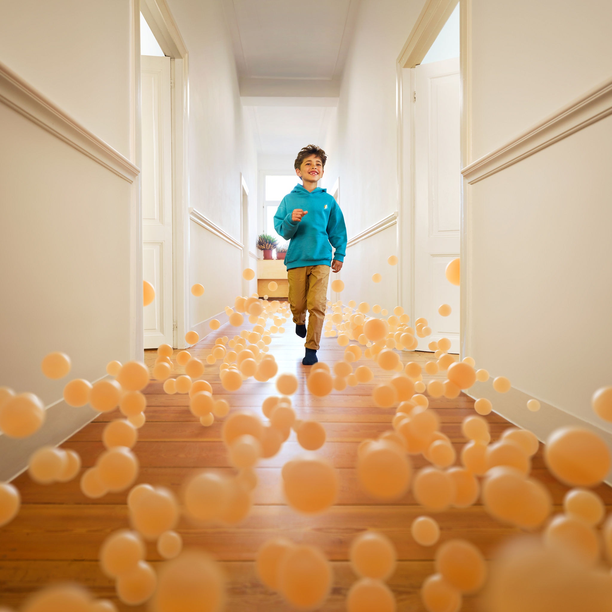 Dreng løber ned ad en gang i et hus med perfekt temperatur takket være en luft-til-luft varmepumpe