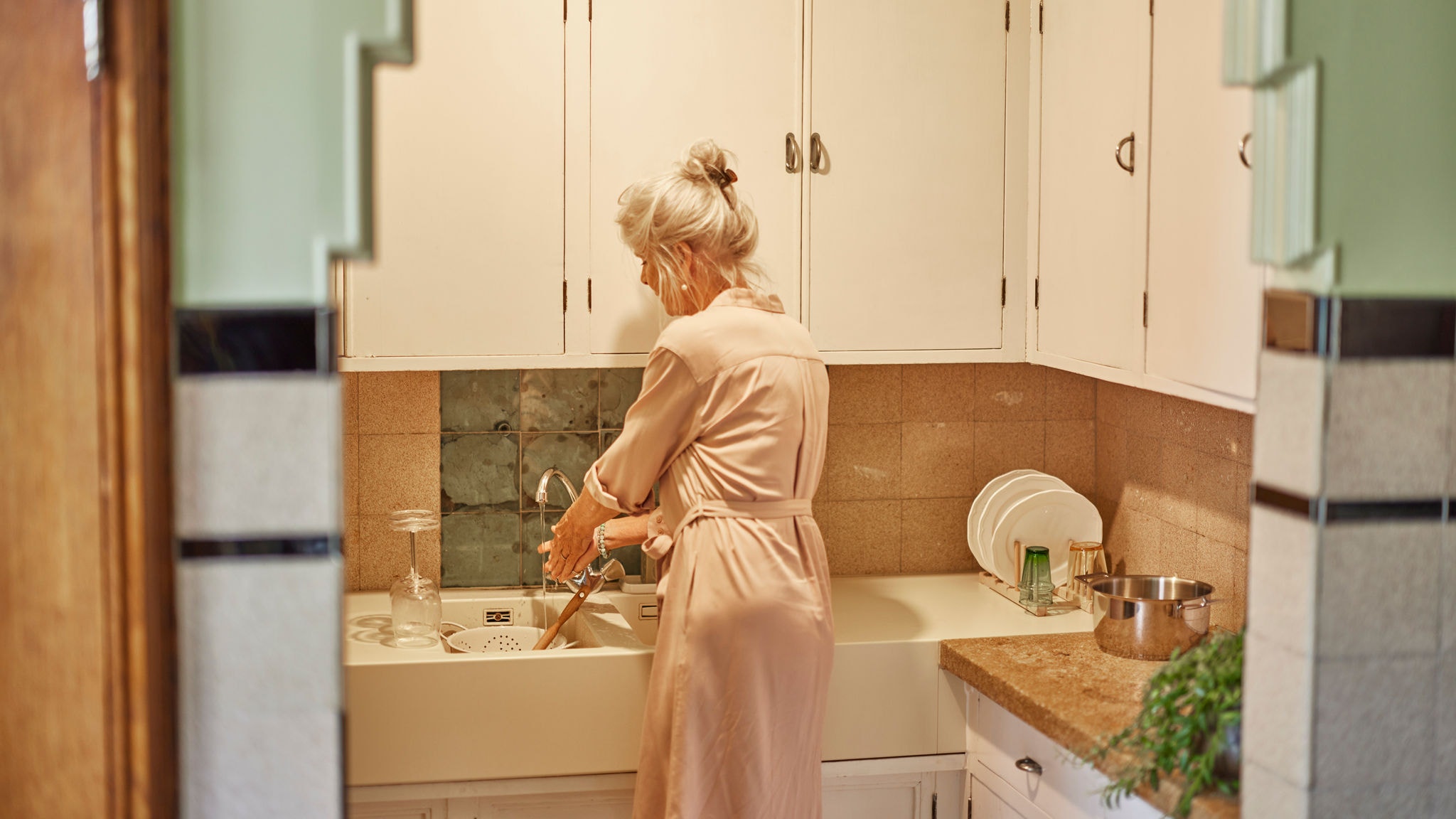 En kvinde vasker op med varmt vand fra Multi Split