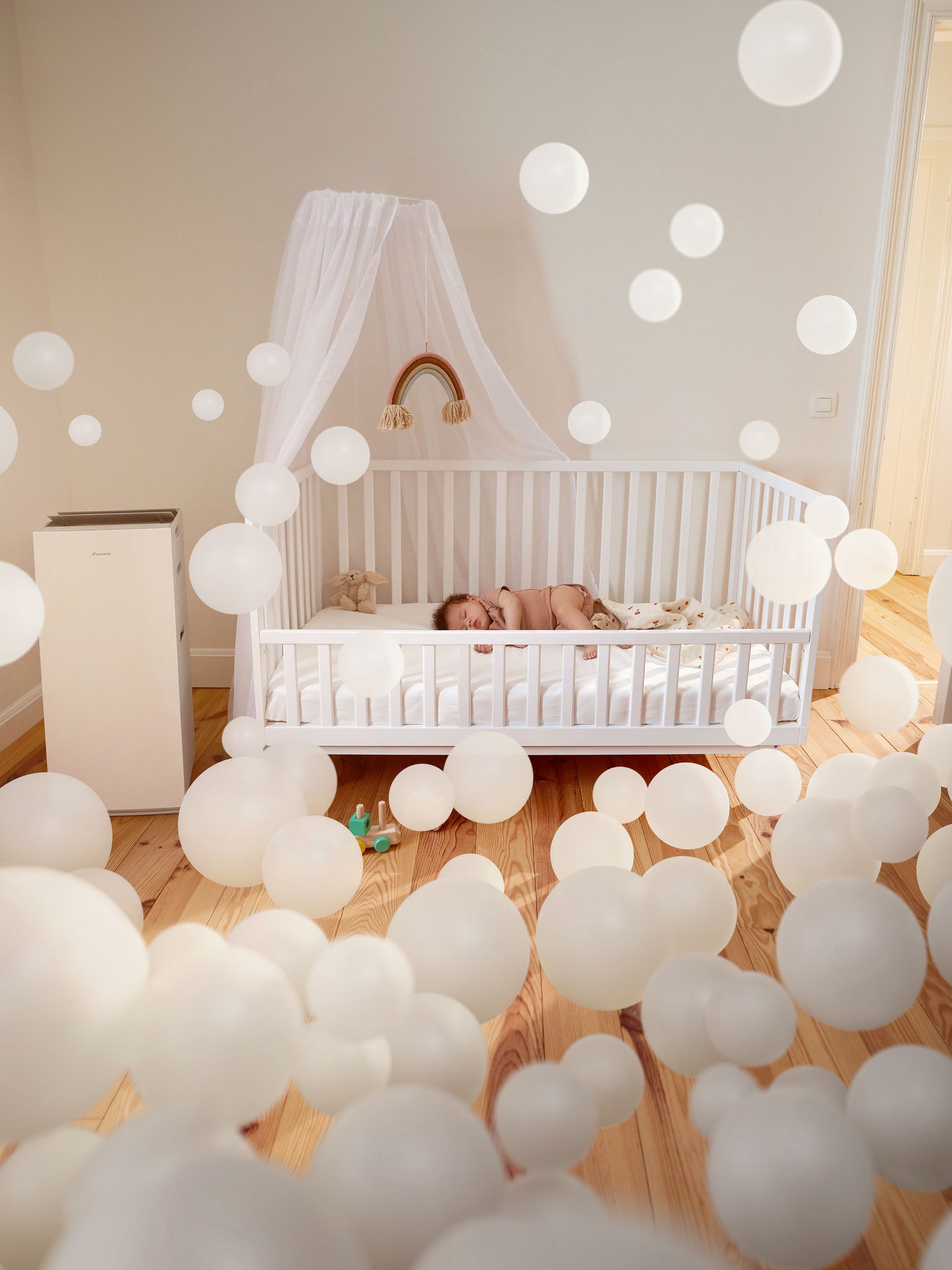 Et spædbarn sover roligt i et børneværelse med en luftrenser og nyder godt af den rene luft og den sunde indendørs luftkvalitet