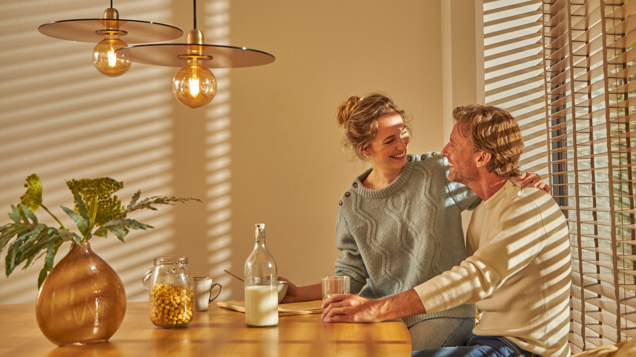 Et par spiser en hyggelig morgenmad sammen i deres behageligt varme køkken takket være denne intuitive opvarmningsteknologi.