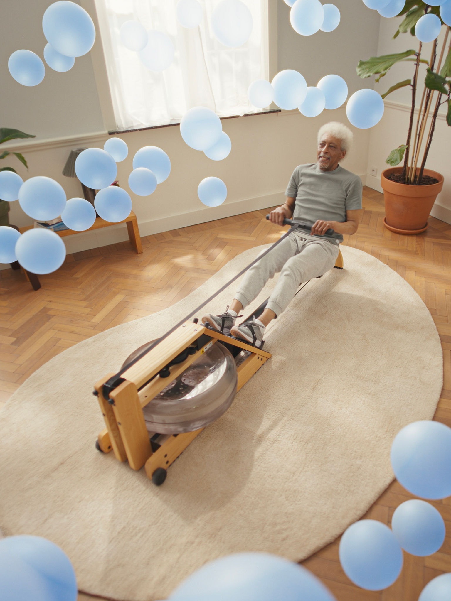 En ældre mand træner på en romaskine i et perfekt klimastyret rum takket være responsiv luft-til-luft-varmepumpeteknologi