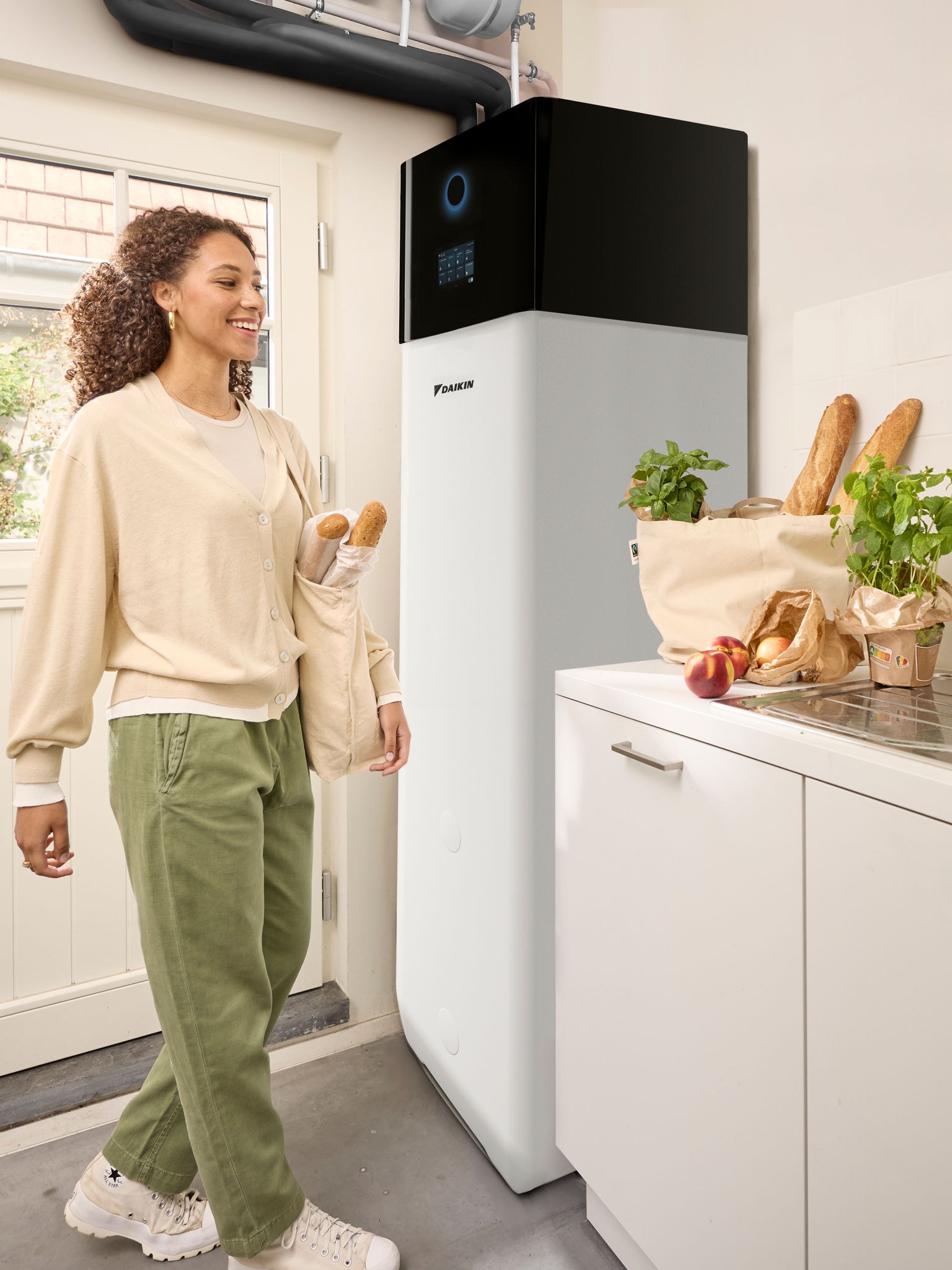 En kvinde kommer hjem med indkøbsposer