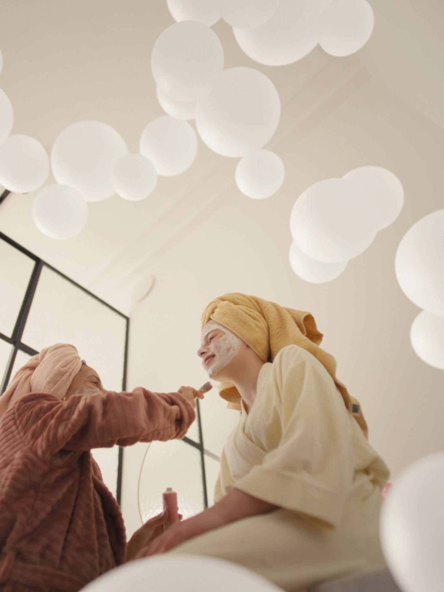 Mor og datter forkæler sig selv med ansigtsmasker i et godt ventileret rum takket være et ventilationssystem