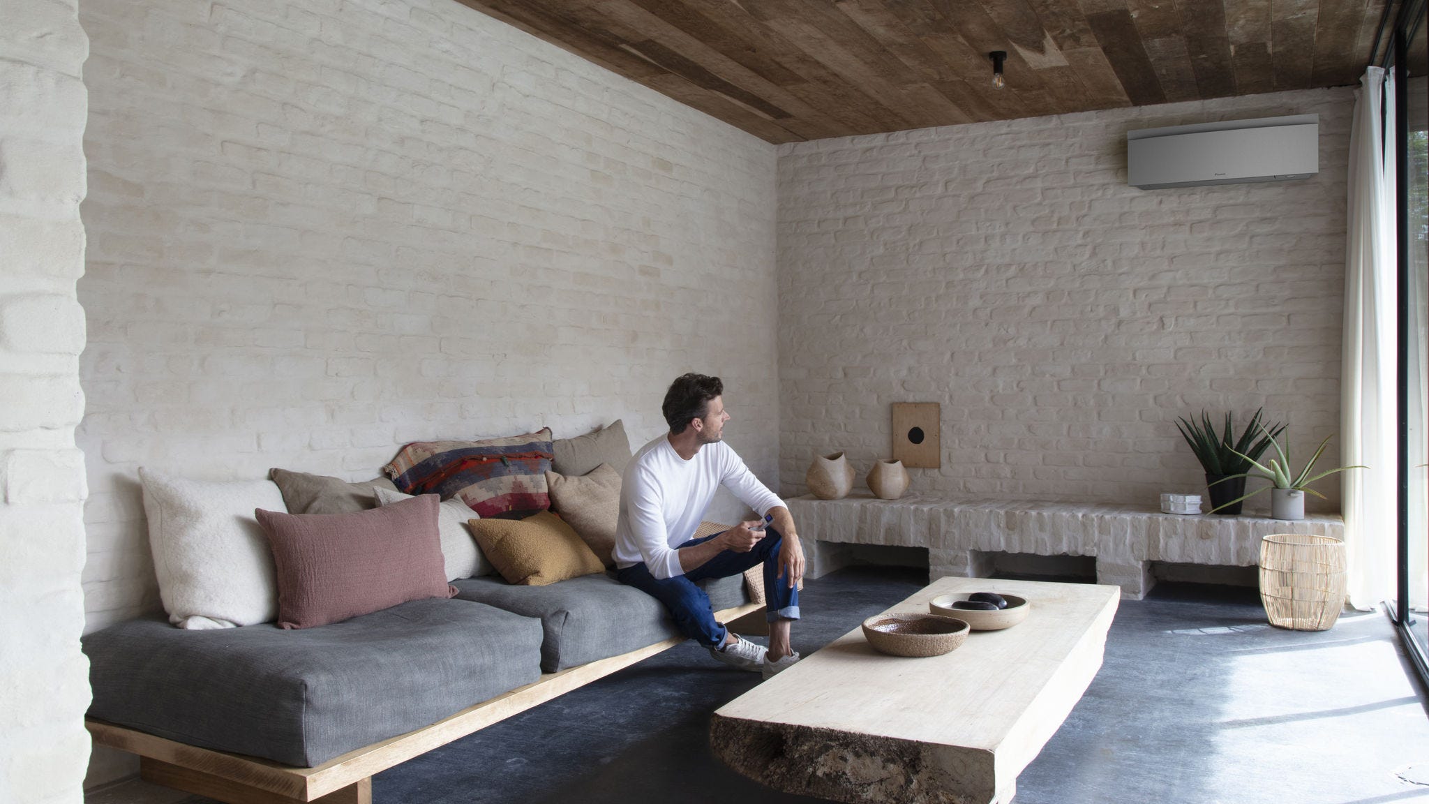 Installatør sætter en flot indendørsenhed op på en væg.