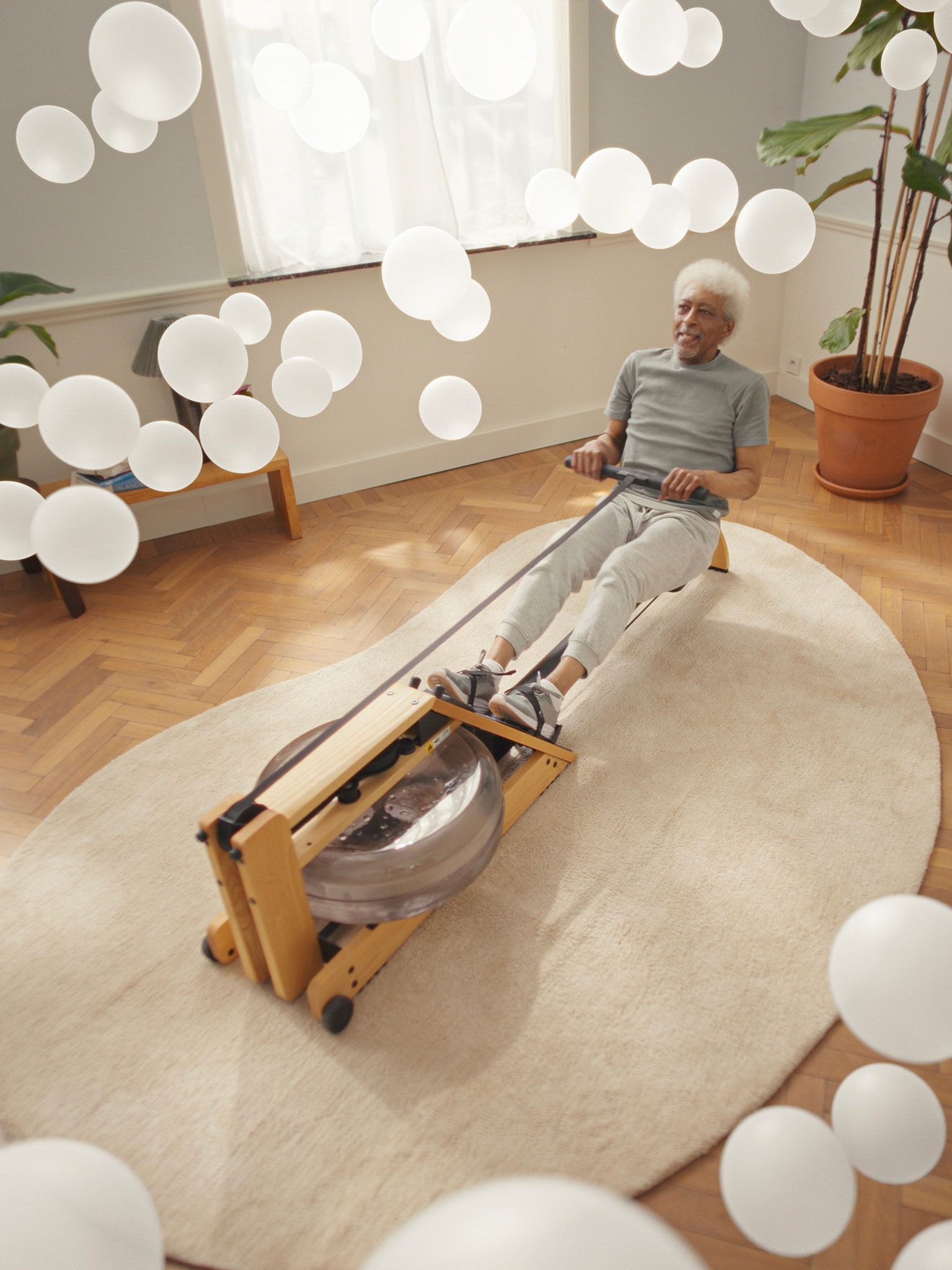 En ældre mand træner på en romaskine i omgivelser med ren luft