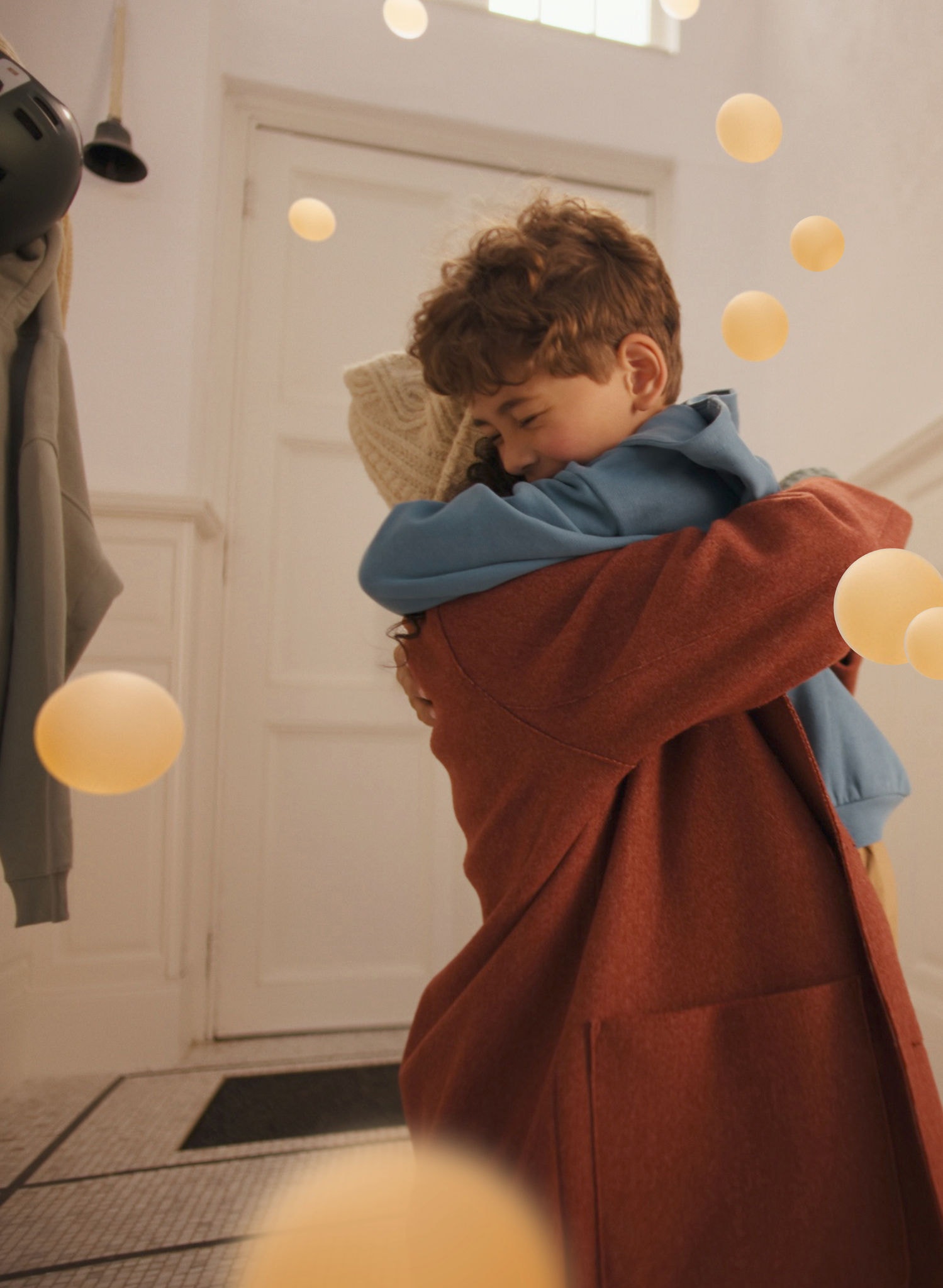 Mor og søn giver hinanden et varmt kram i et stilrent og fredfyldt opholdsrum med støjsvag komfort takket være en Daikin luft-til-luft-varmepumpe