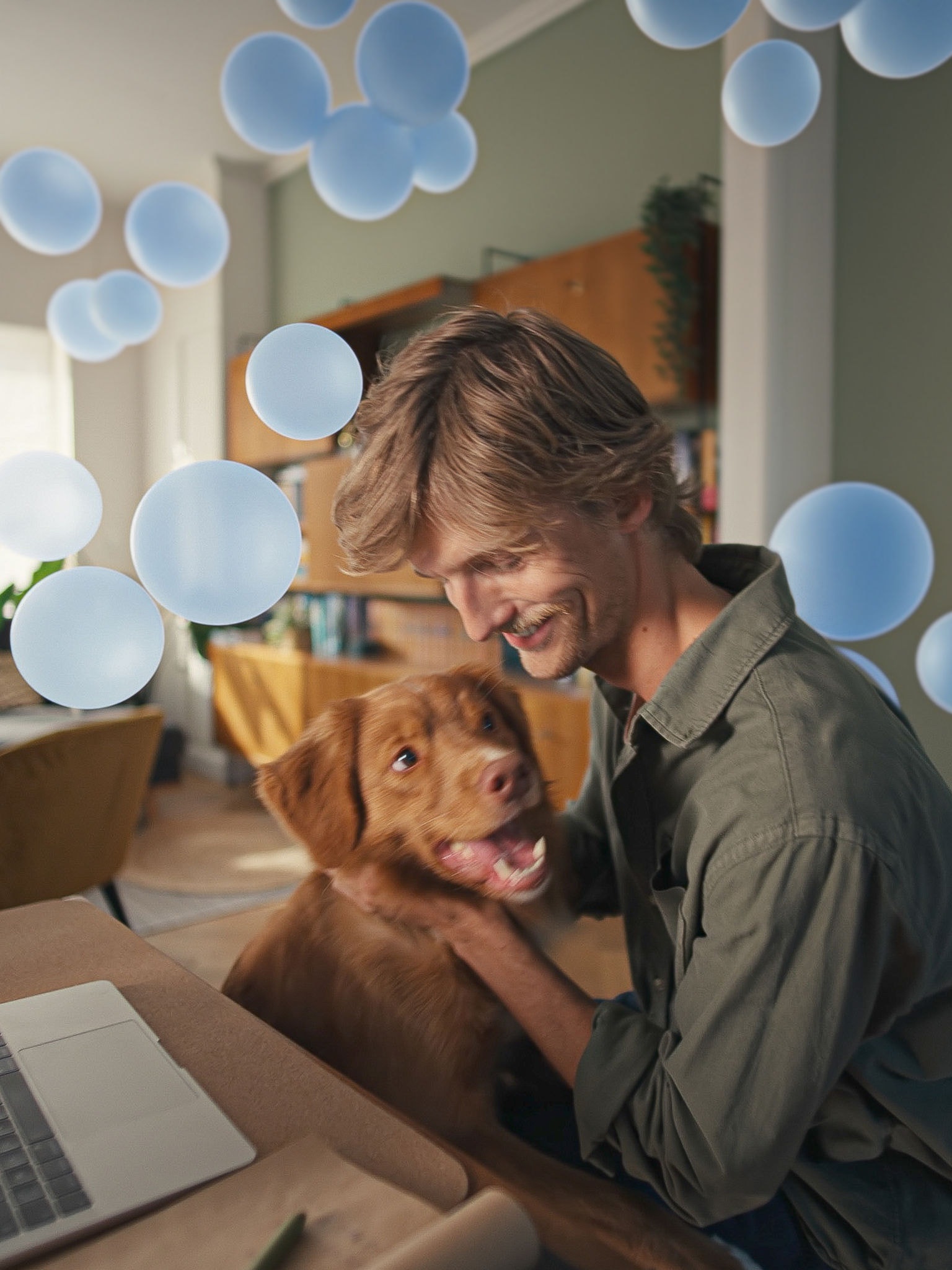 En ung mand sidder ved sit skrivebord med sin hund og nyder den støjsvage komfort og smarte klimastyring