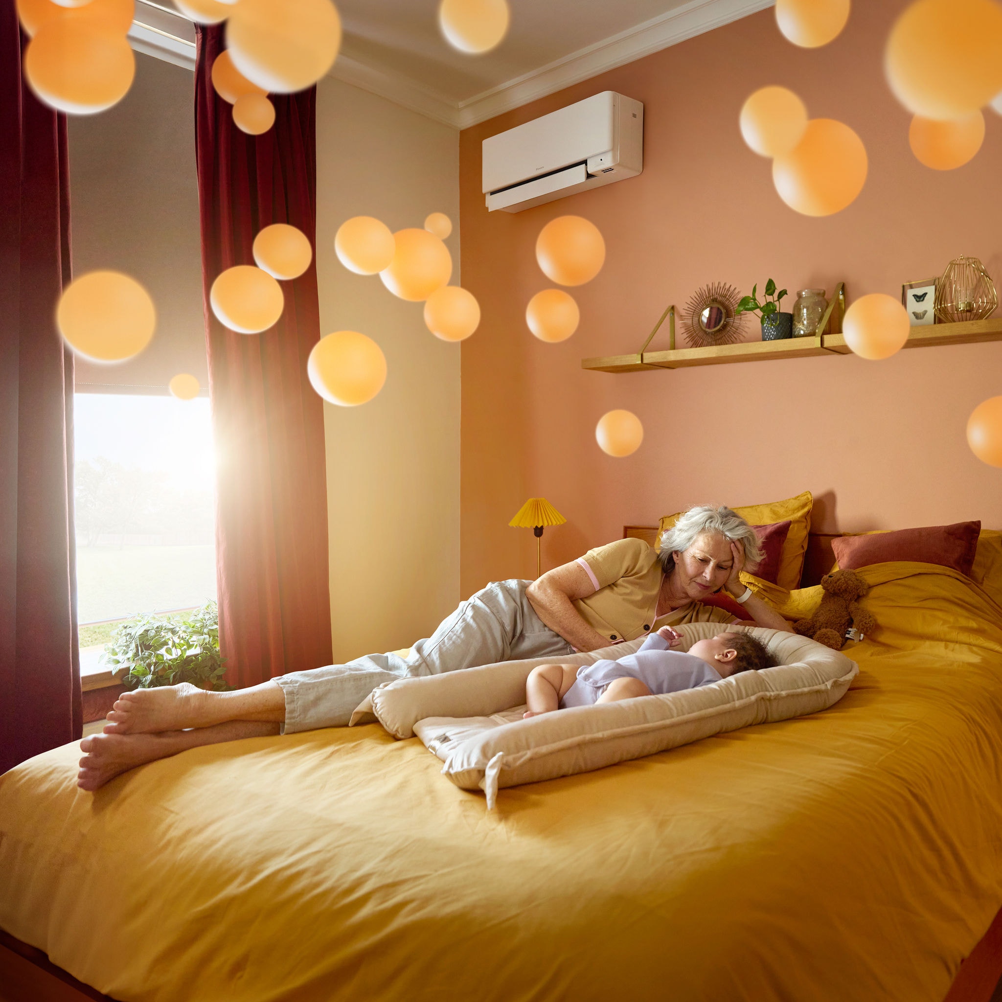 En bedstemor ligger ved siden af et spædbarn, der sover fredfyldt i et roligt, behageligt opvarmet rum takket være en lydsvag luft-til-luft varmepumpe