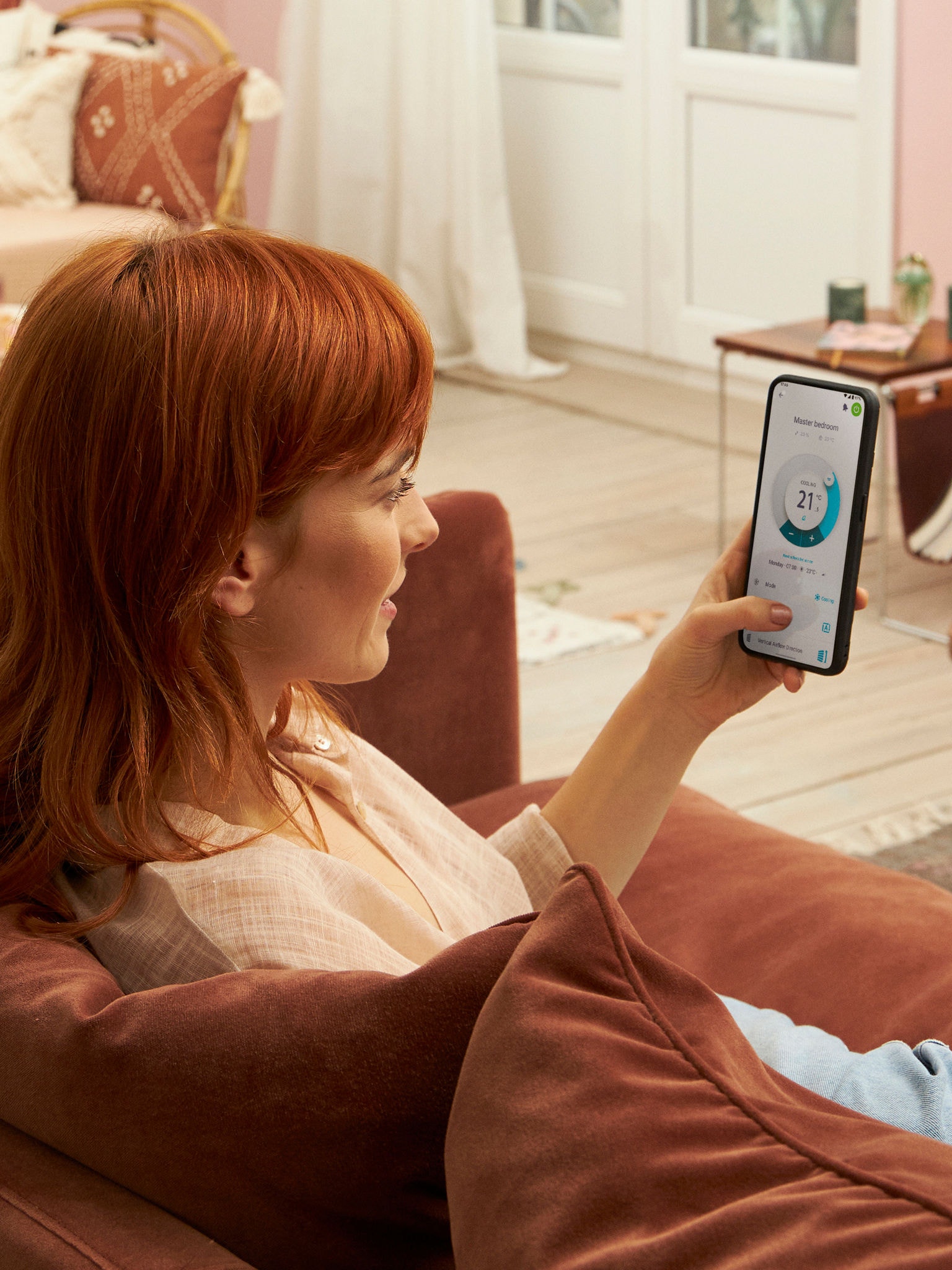 En kvinde betjener hver enkelt indendørsenhed med Onecta-appen