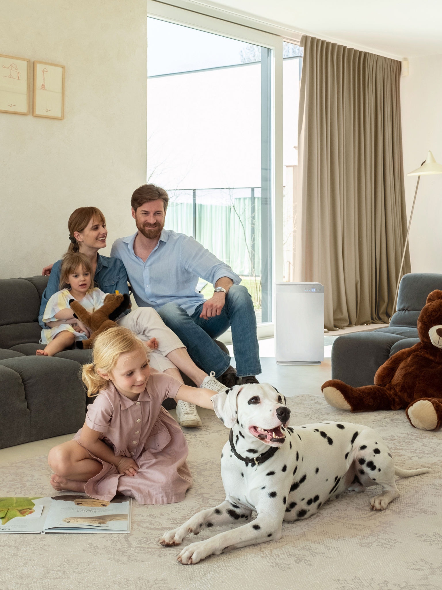 Familie med to børn og en dalmatiner, der slapper af i stue med god luftkvalitet