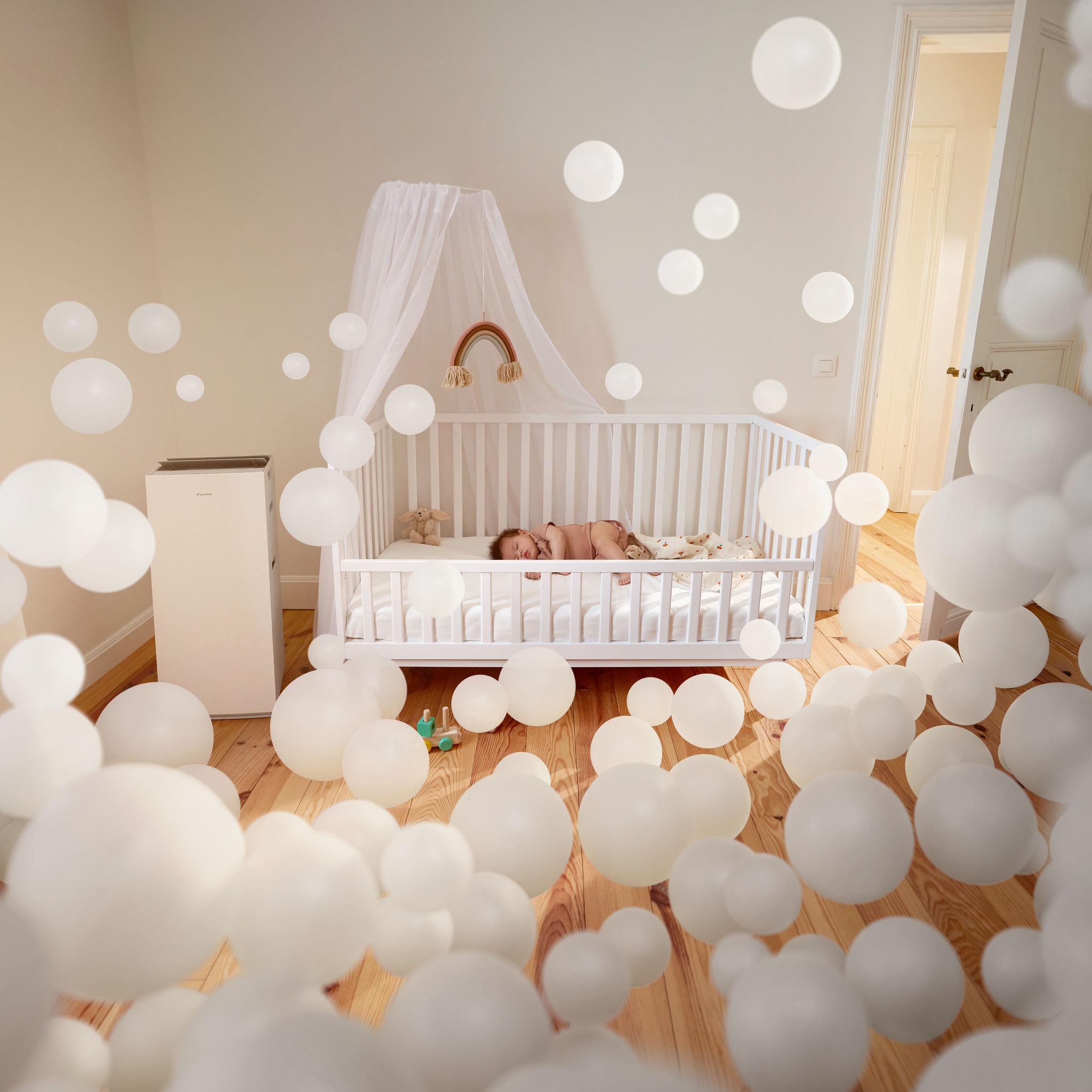 Et spædbarn sover roligt i et børneværelse med en luftrenser og nyder godt af den rene luft og den sunde indendørs luftkvalitet