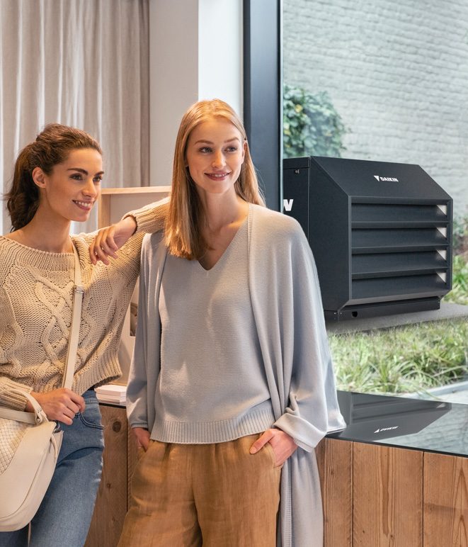 To personer nyder deres lydsvage Daikin-enhed.